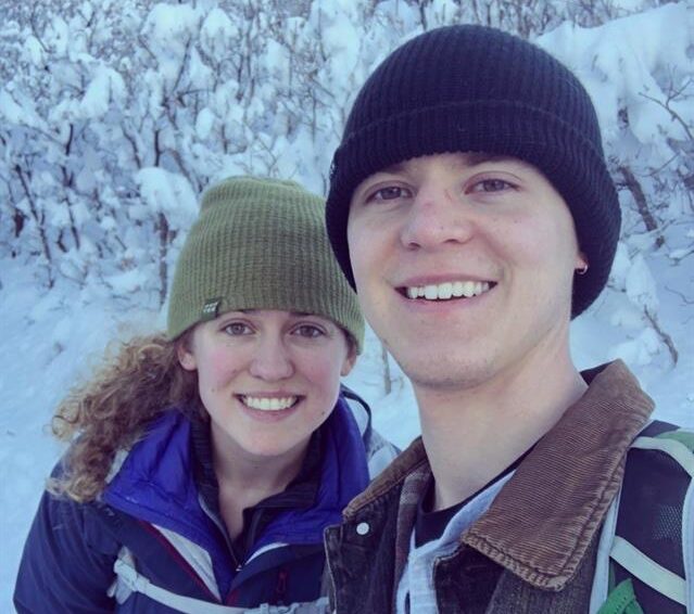 kelly and fiance smiling, snow in background on trees