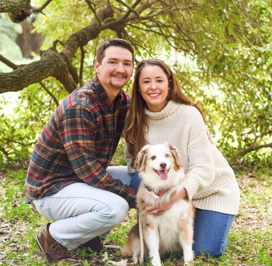meagan and husband in kneeling pose with their dog