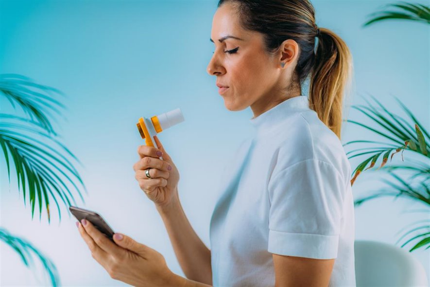 woman holding spirometer and iphone